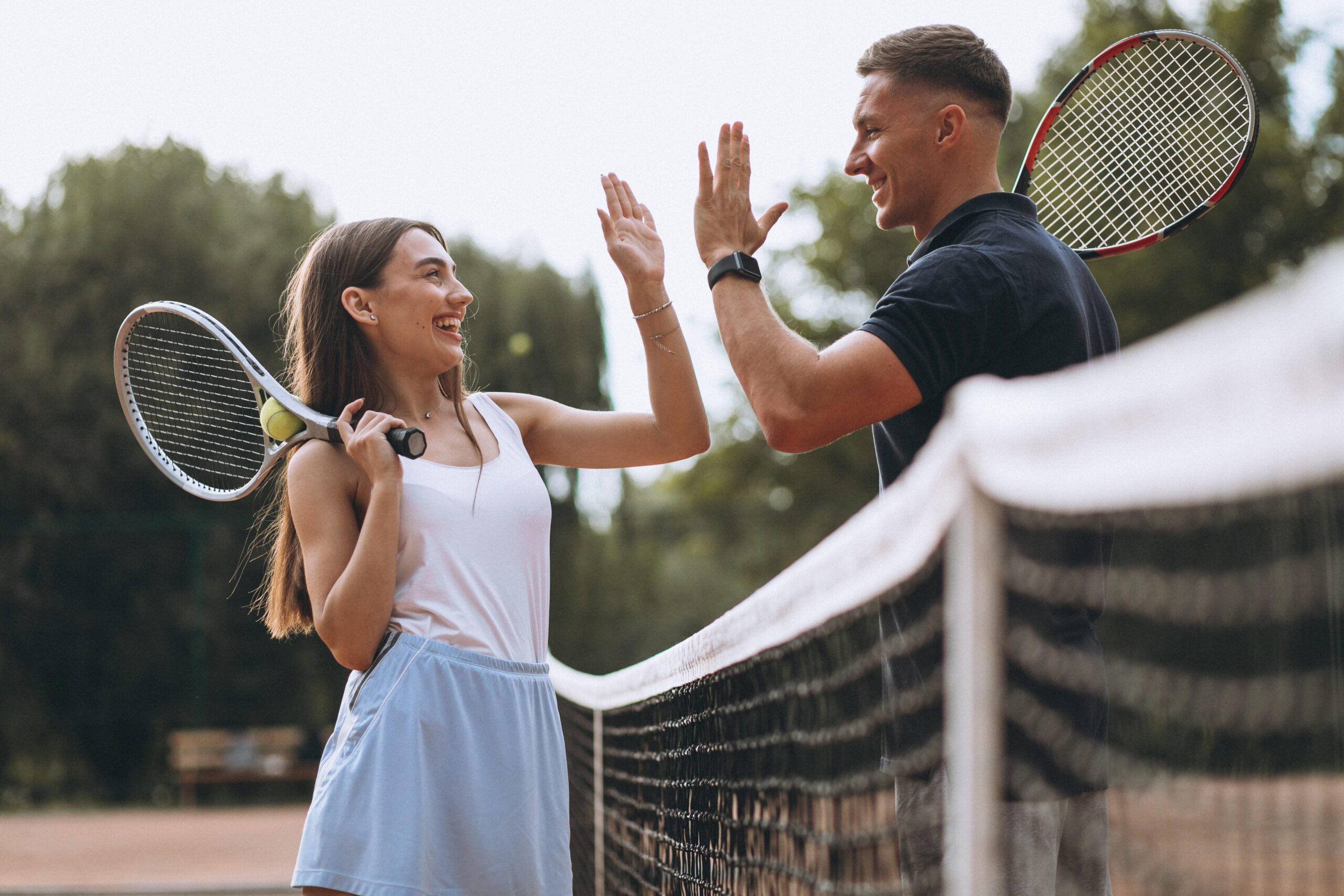 Young couple playing tennis at the court